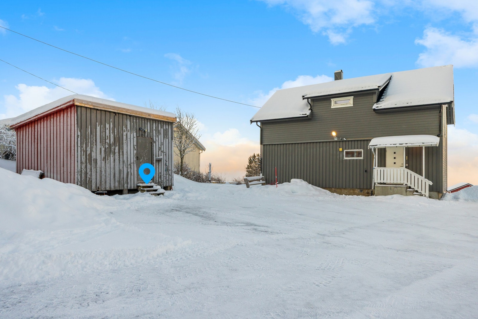 Eiendommen har et stort, opparbeidet parkeringsareal og en frittliggende utebod. Galleribilde
