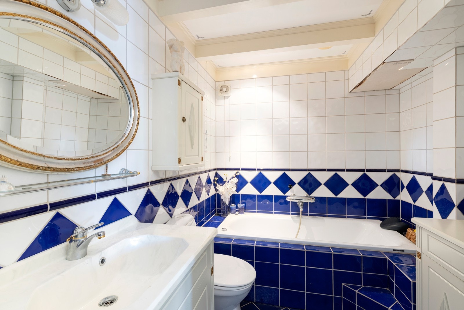 Helfliset bad nede med badekar. Skade i tak (høyre i bilde) stammer fra lekkasje fra bad over. Galleribilde