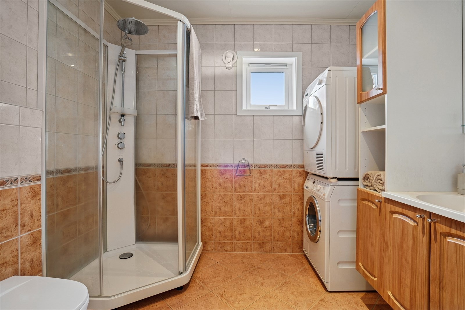 Badet har flislagt gulv utstyrt med elektriske varmekabler som gir lun komfort - Veggene er flislagt, mens himlingsplater i taket gir et lyst og ryddig inntrykk Galleribilde