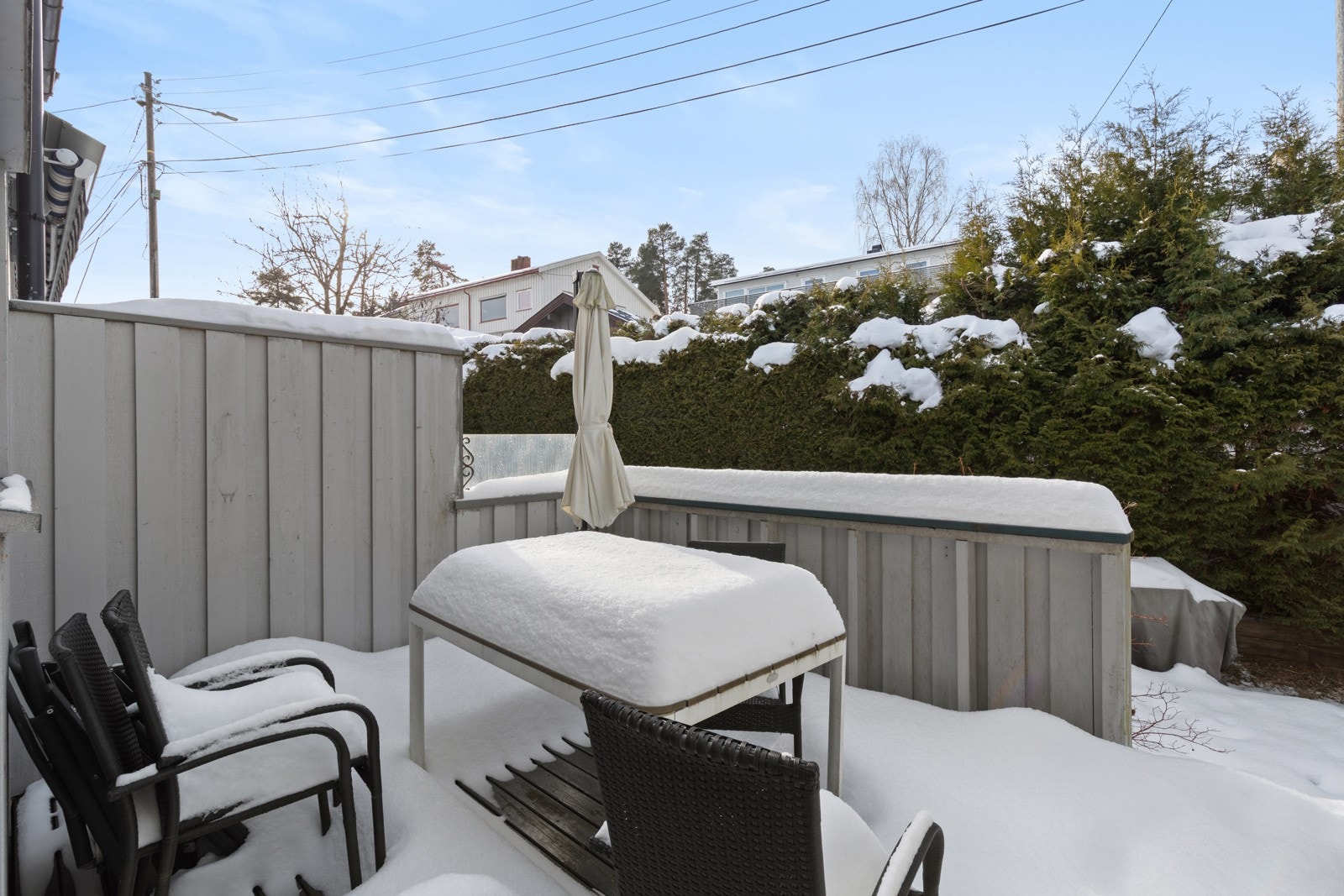Terrassen er solrik og skjermet av hekk Galleribilde