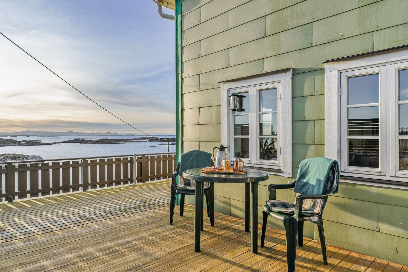 Romslig terrasse som strekker seg rundt store deler av boligen Galleribilde