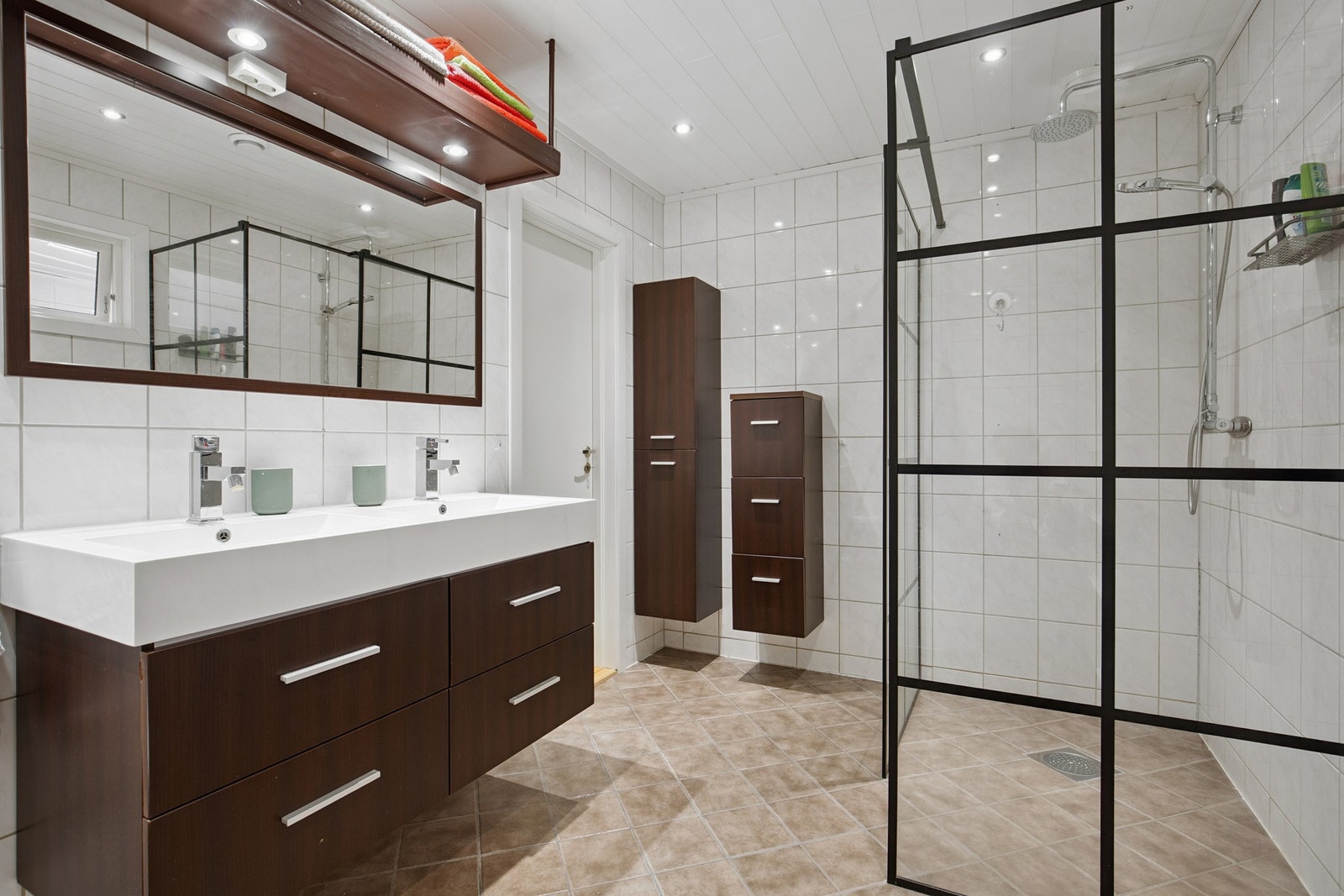 Badet har dobbelservant og romslig dusjnisje Galleribilde