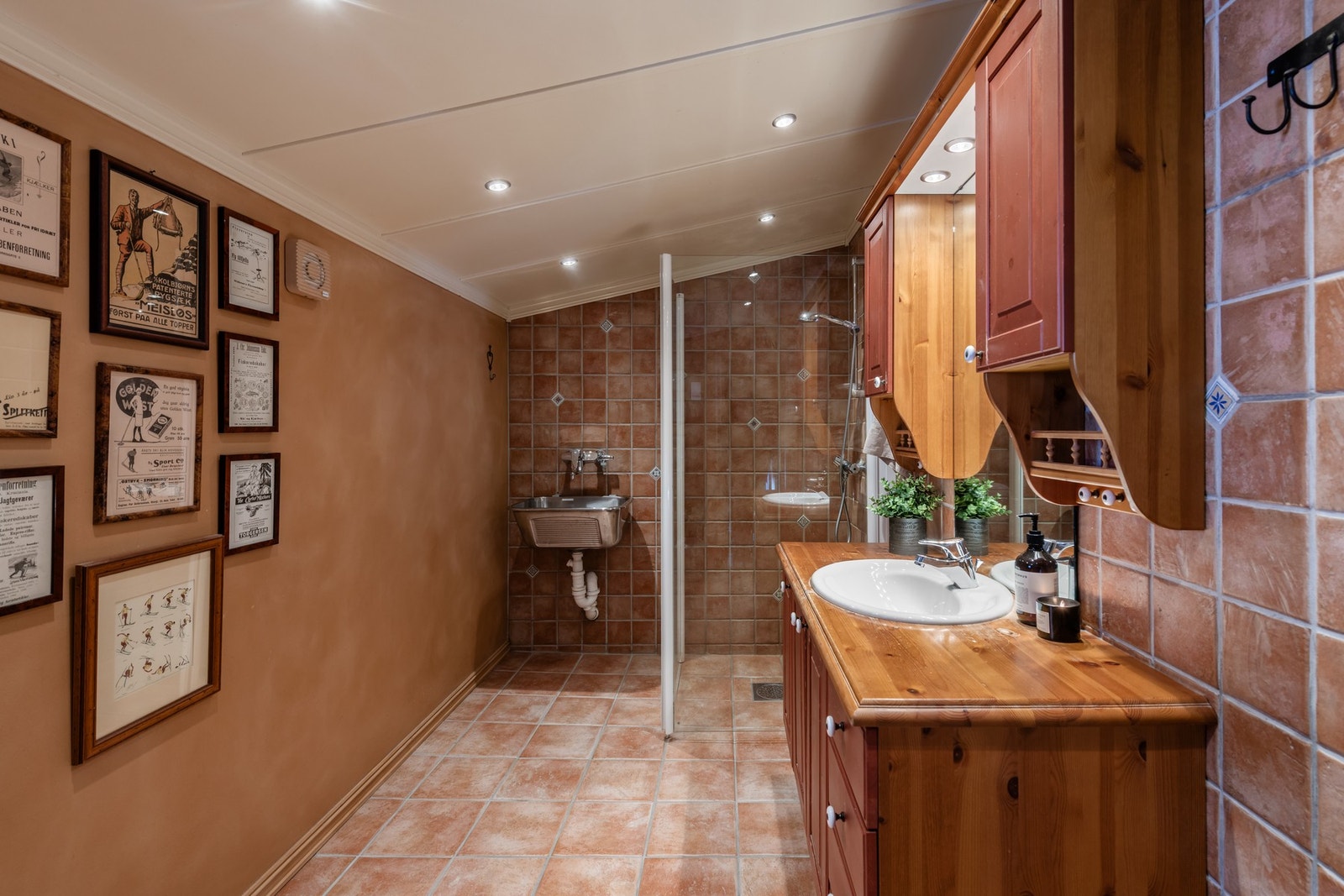 Badet har flislagt gulv, fliser i dusj-nisje og ved vask Galleribilde