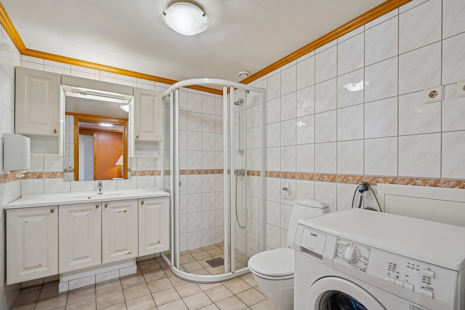 Flislagt bad med innredning, dusj og toalett. Opplegg for vaskemaskin Galleribilde