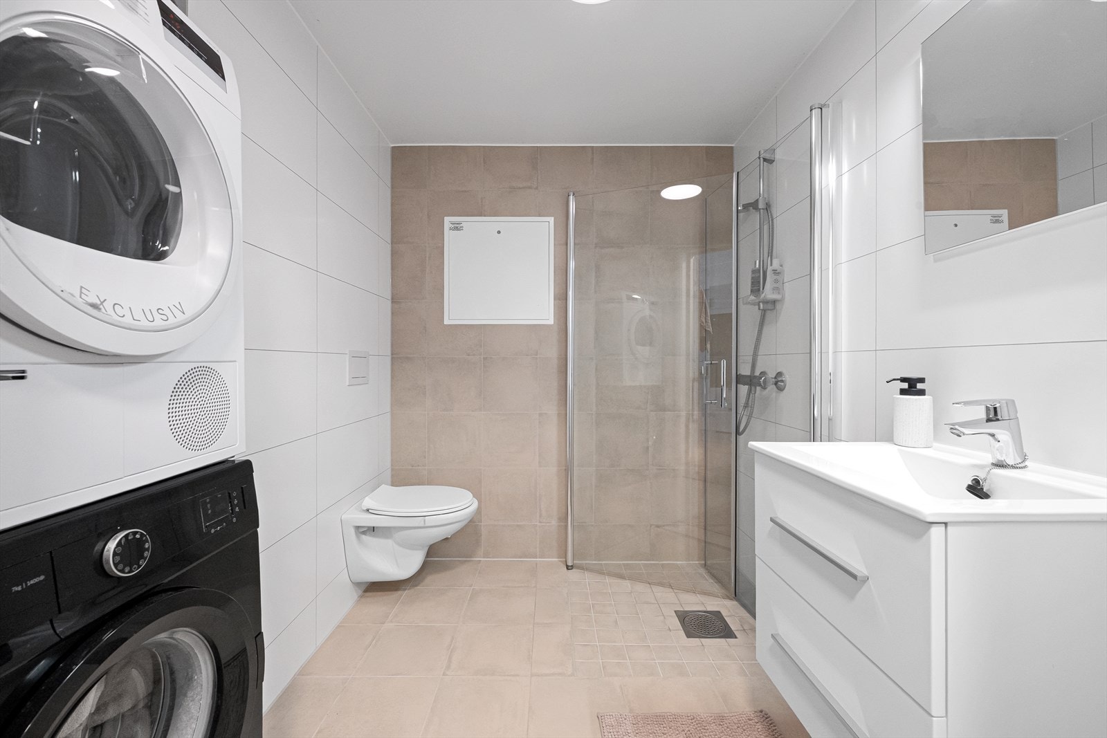 Helfliset bad med god plass til vaskemaskin og tørketrommel Galleribilde