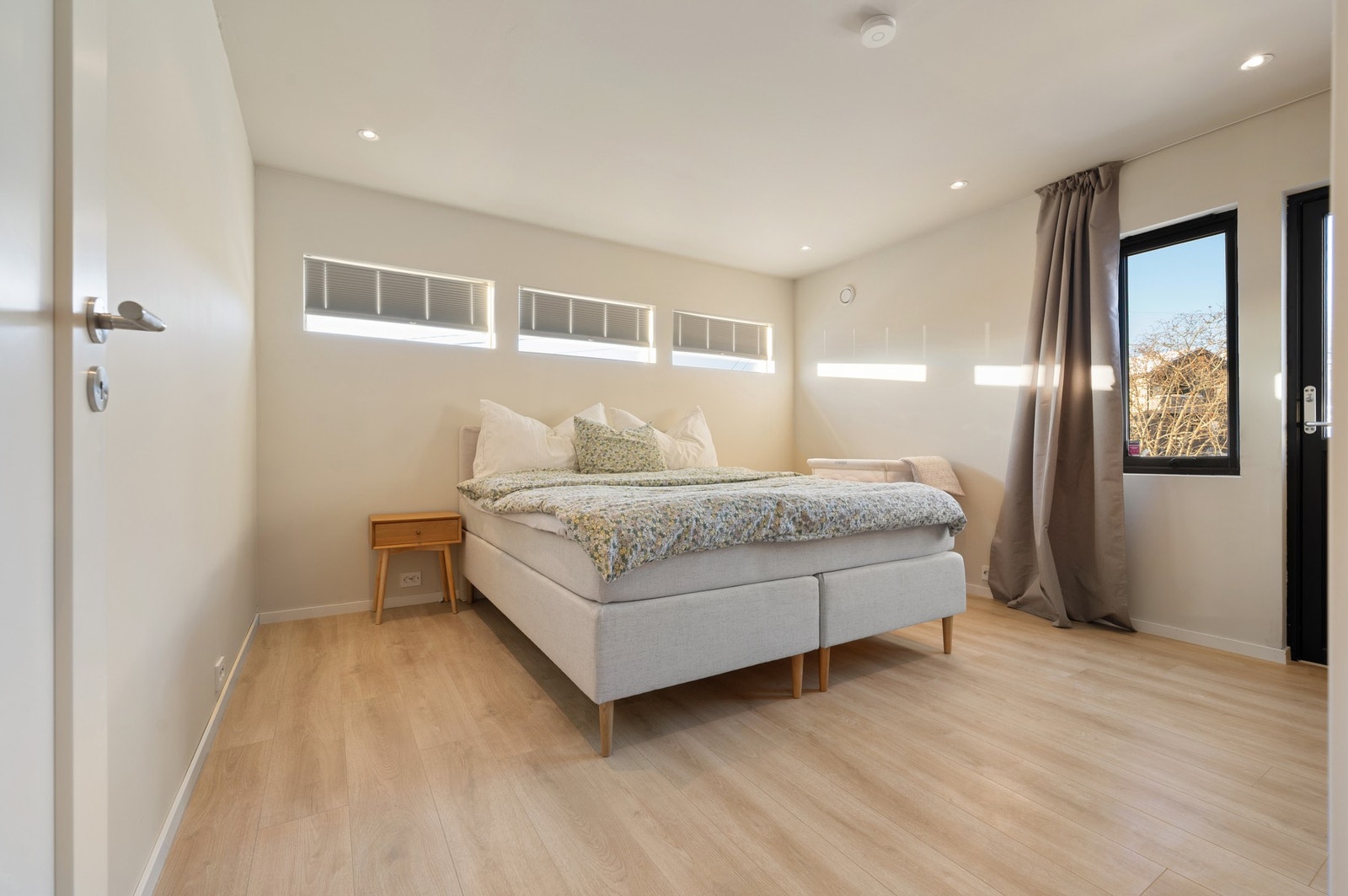 Romslig hovedsoverom innredet med dobbeltseng og garderobeløsning Galleribilde