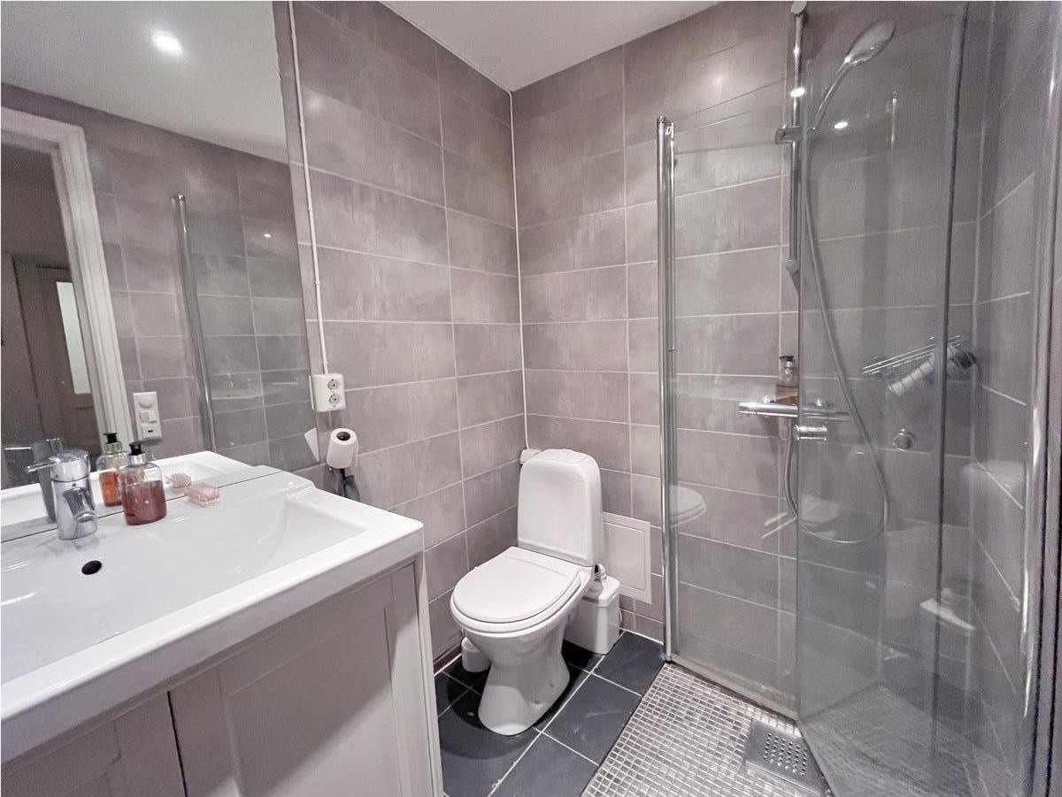 Flislagt delikat bad med gulvvarme og stor vask Galleribilde