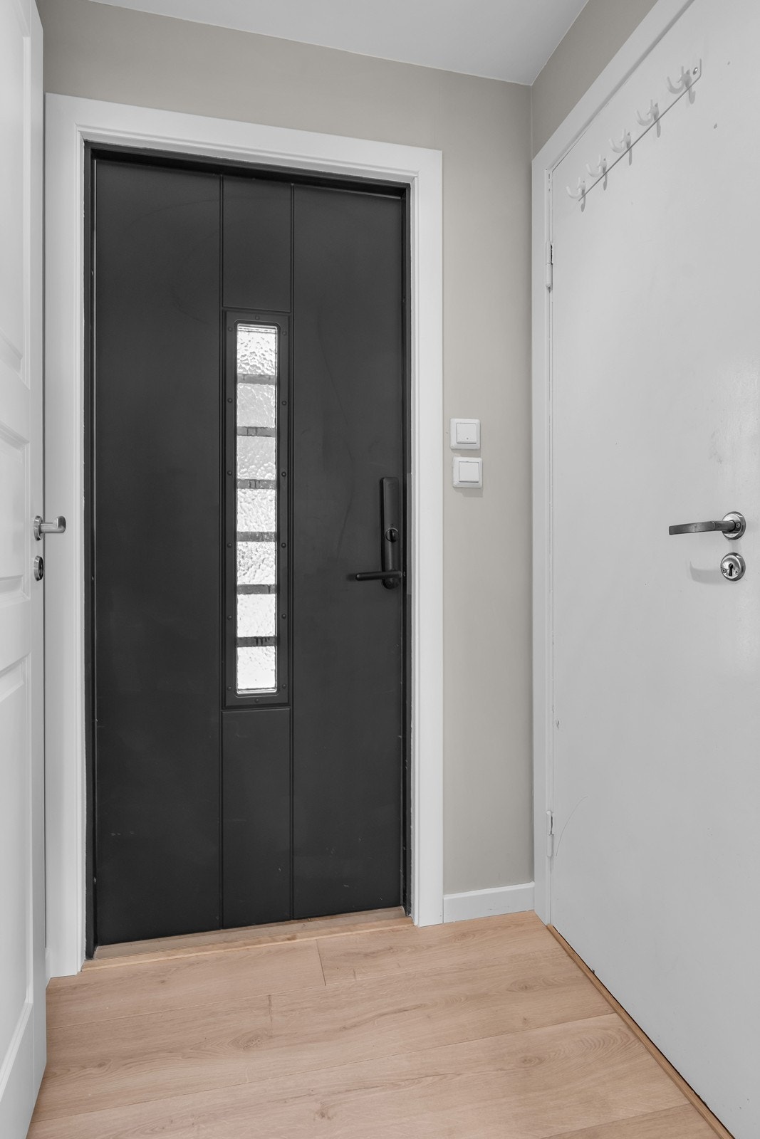 Velkommen inn! Vindfanget gir et godt førsteinntrykk av boligen, og har nye laminatgulv og helsparklede - og malte overflater noe som er gjennomgående for 1. etasje. Døren til høyre er inn til en liten bod Galleribilde