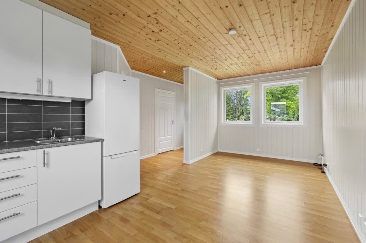 Leiligheten har en åpen stue- og kjøkkenløsning med parkett på gulvet. Galleribilde