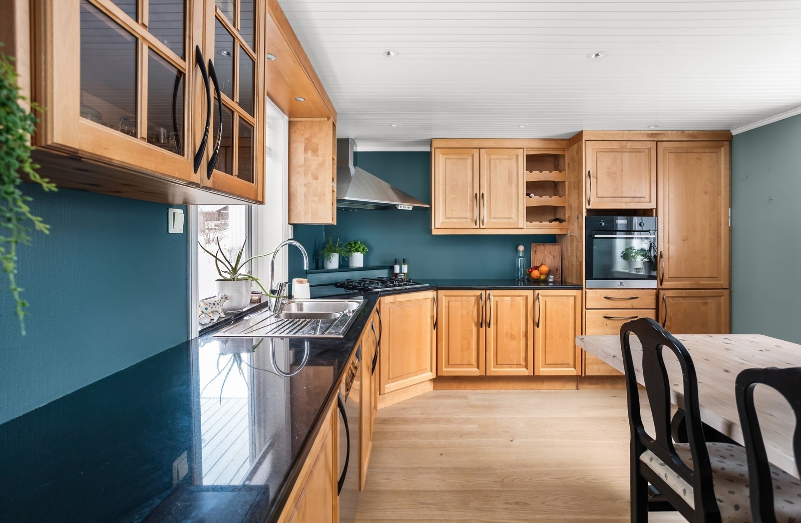 Praktisk dobbel kjøkkenkum i stål og overskap med glassfelt. Galleribilde