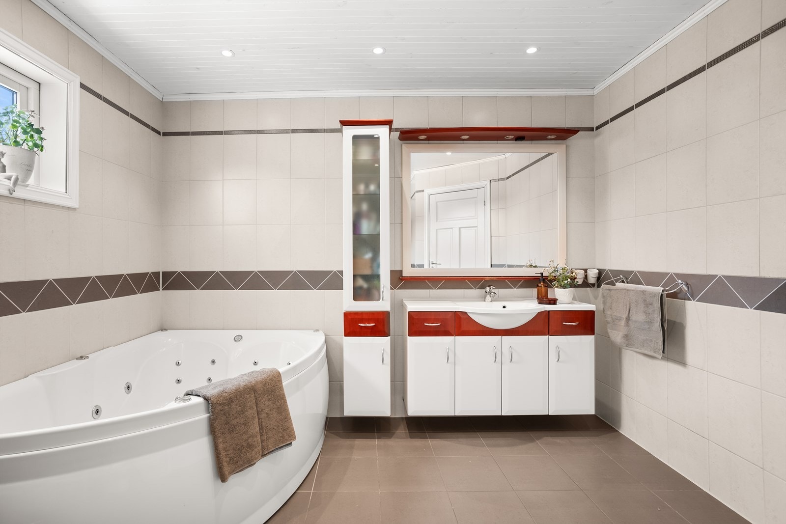 Baderomsinnredning med servant, underskap og speil med belysning. Galleribilde