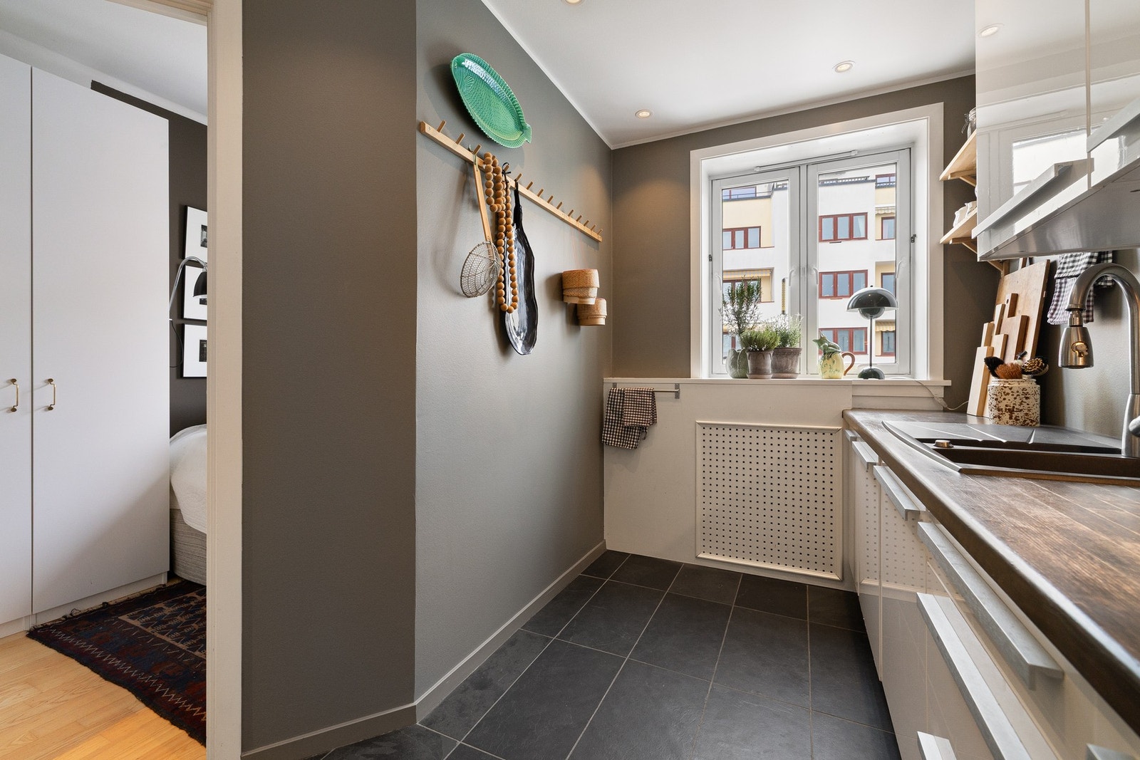 Kjøkkenet har innredning fra IKEA med glatte fronter og heltre benkeplate, som gir et stilrent og tidløst uttrykk. Benkeplassen er godt utnyttet, og løsningen har god arbeidsflyt med oppbevaring i både under og overskap samt åpne hyller. Galleribilde