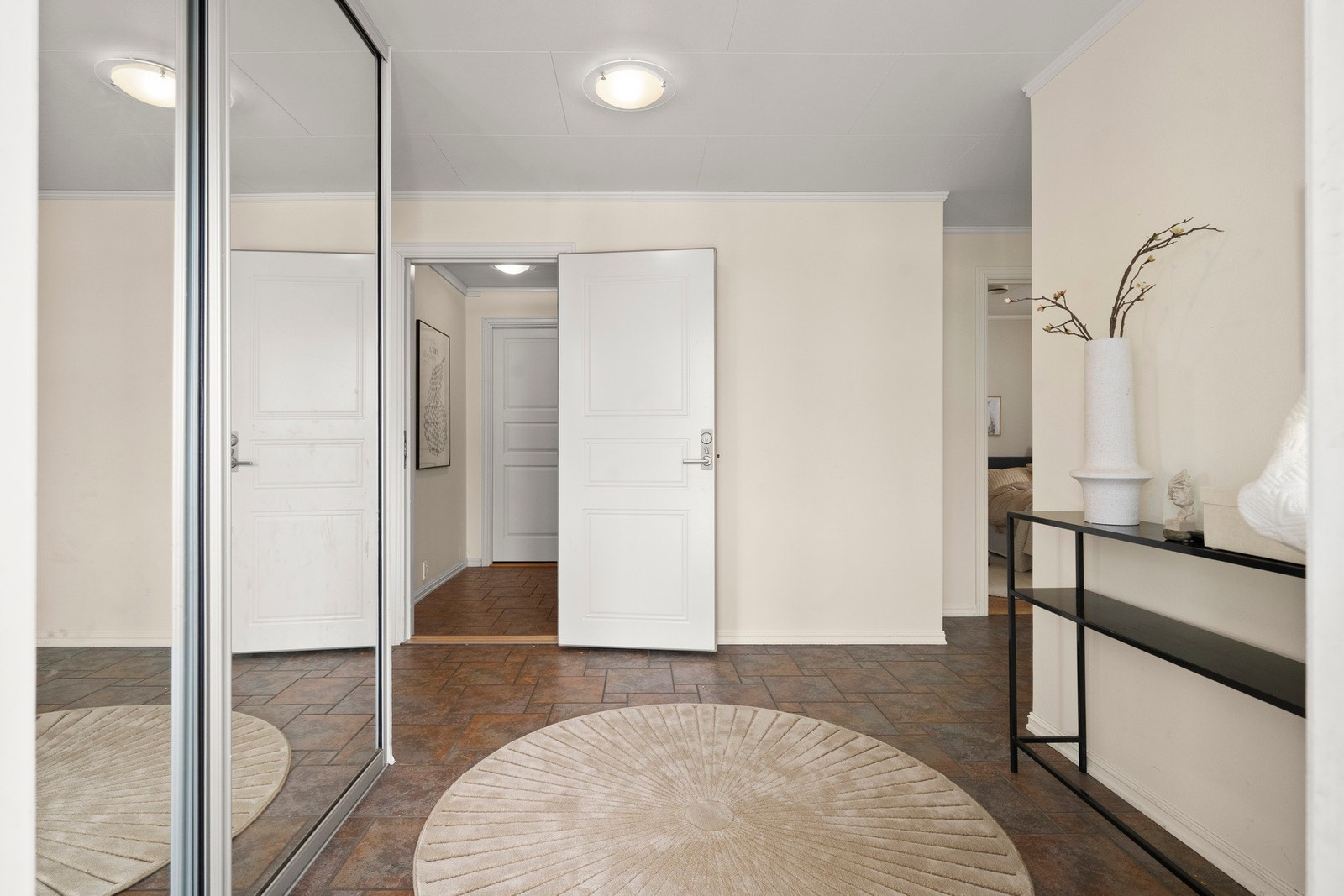 Stor, flislagt hall med skyvedørsgarderobe Galleribilde