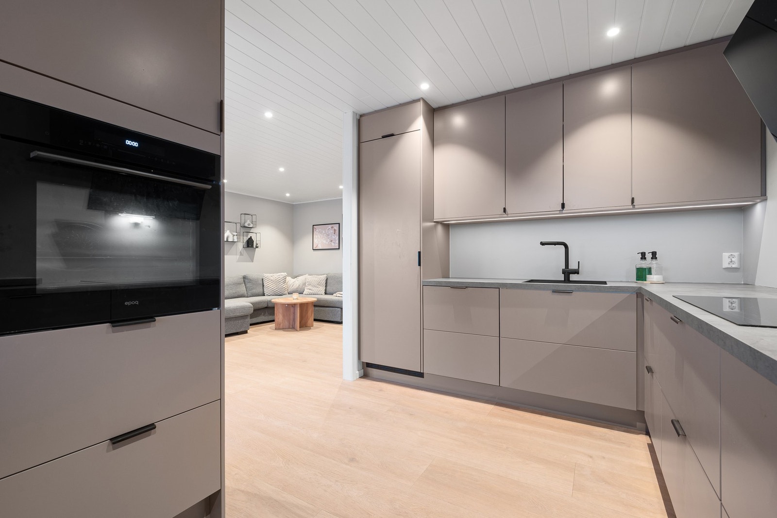 Kvalitetskjøkken med integrerte hvitevarer som inkluderer kjøleskap, oppvaskmaskin, induksjonstopp og stekeovn Galleribilde