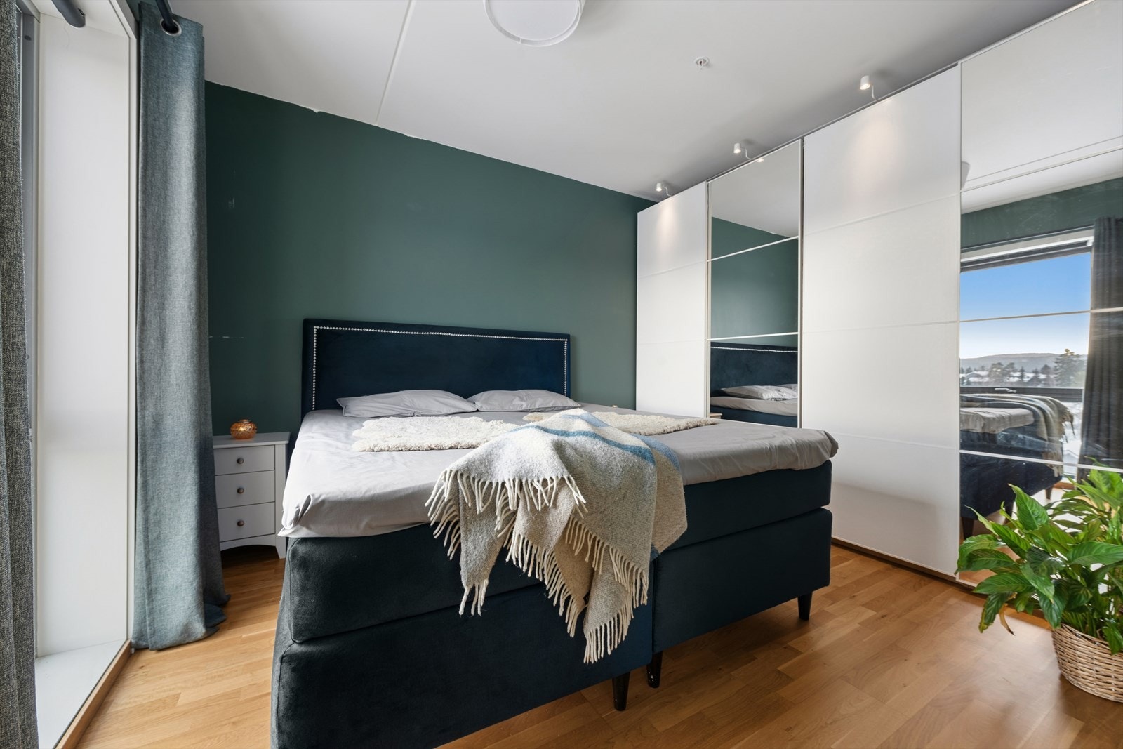 Romslig soverom med plass til seng og en praktisk skyvedørsgarderobe. Galleribilde