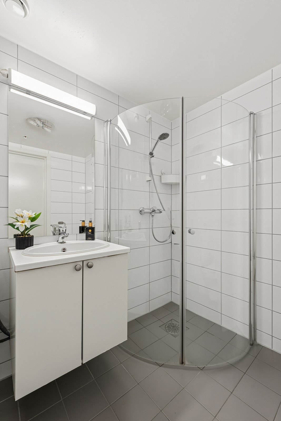 Rommet har innredning med nedfelt servant, veggmontert toalett, dusjhjørne og opplegg for vaskemaskin. Galleribilde