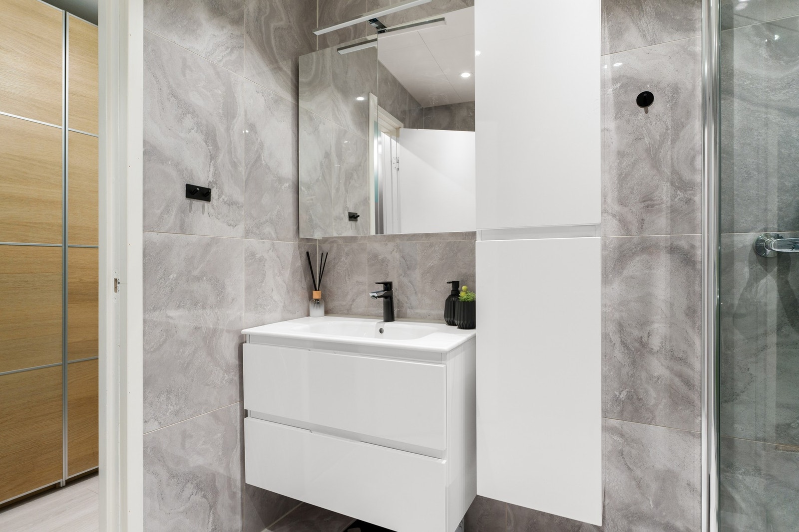 Lys baderomsinnredning og speilskap som gir godt med oppbevaringsplass. Galleribilde