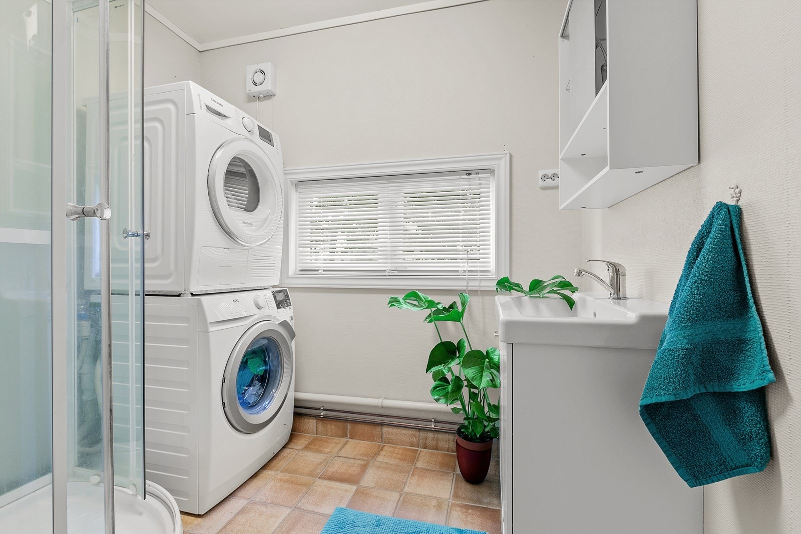 Bad/vaskerom i 1. etasje med malt glassfiberstrie på vegger og flislagt gulv, med varmekabler Galleribilde