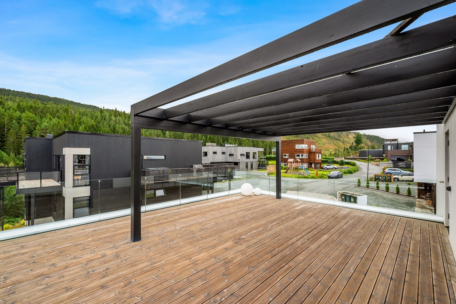 Her kombineres delvis overbygg med åpne flater, elegante glassrekkverk og solide terrassebord - et sted som inviterer til ro og kvalitetstid. Galleribilde