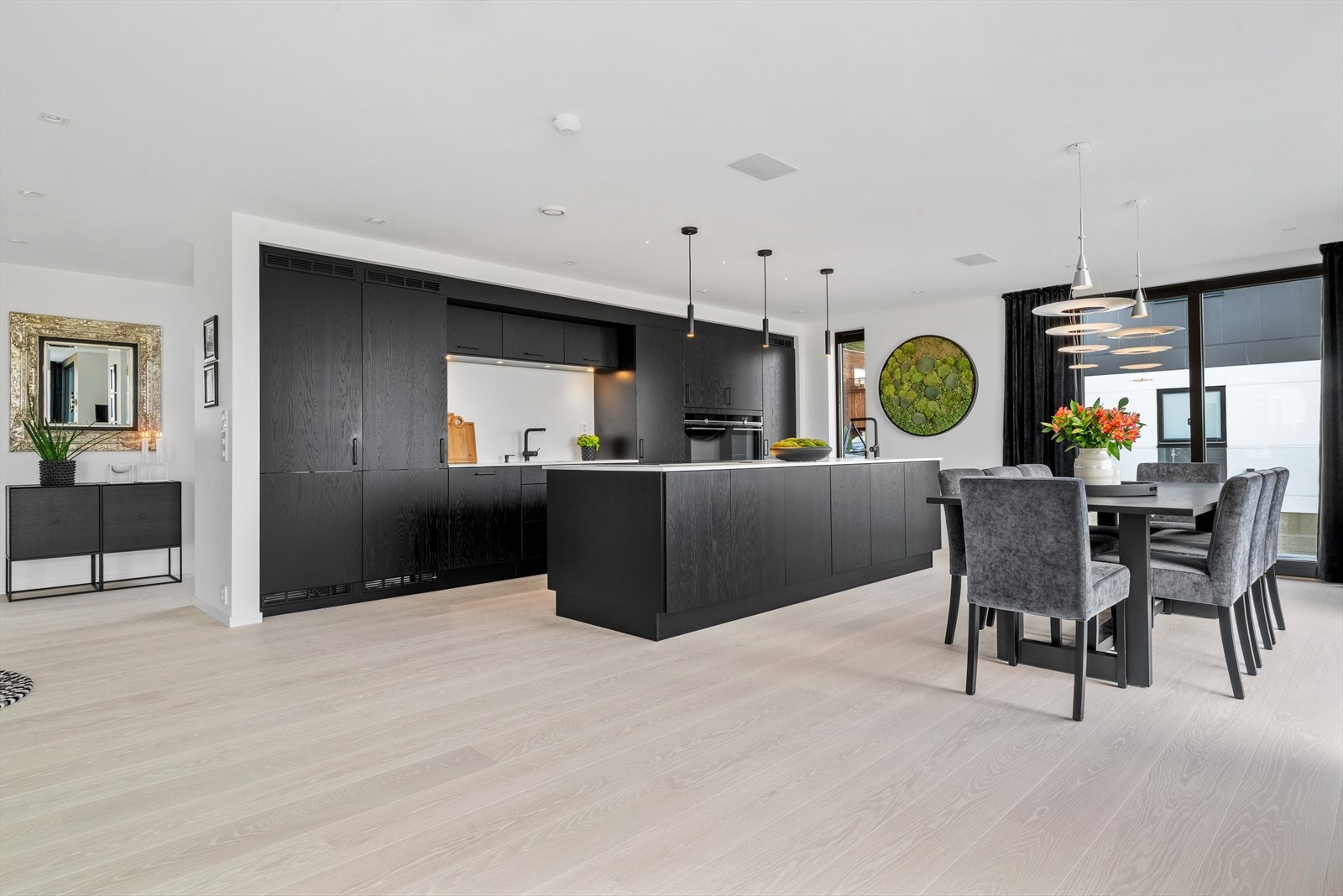 Boligen byr på en stilren og moderne planløsning der kjøkken og spisestue smelter sømløst sammen - perfekt for både hverdagsliv og hyggelige måltid. Galleribilde