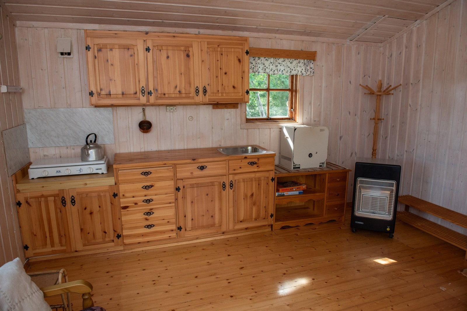 Kjøkkenkrok i gjestehytta. Vindu på denne veggen er i dårlig stand. Galleribilde