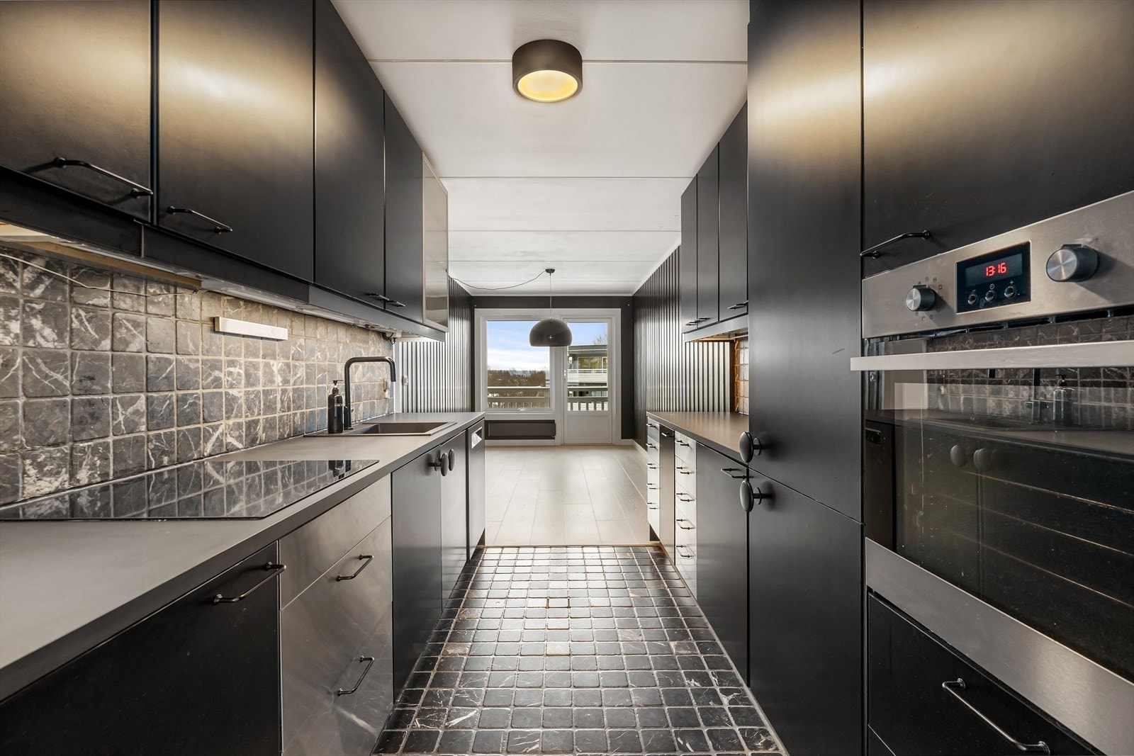 Kjøkkenet har innredning med glatte fronter i stål og laminat. Galleribilde