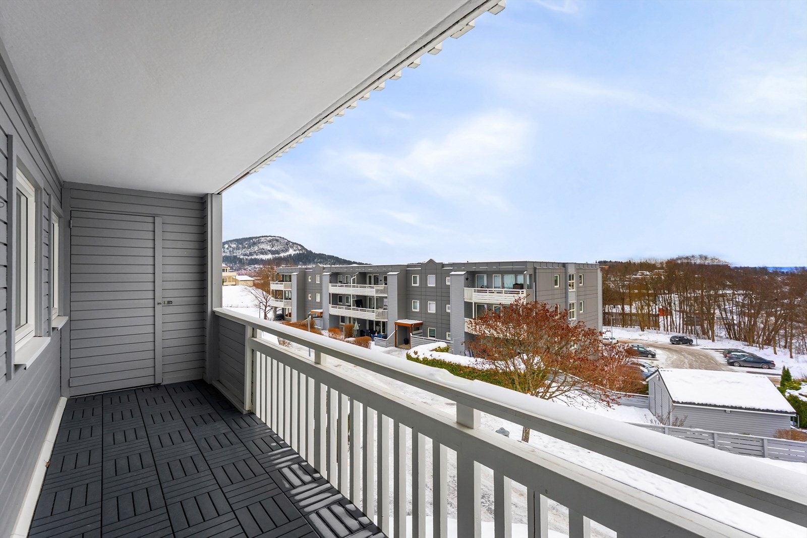 Fin utsikt fra balkongen på kjøkkensiden, med morgensol og utvendig bod. Galleribilde