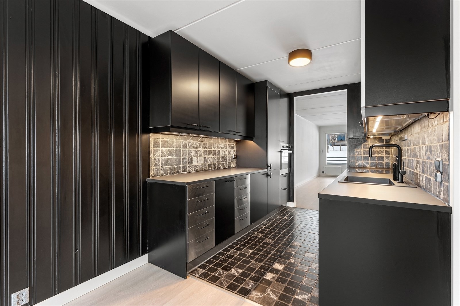 Kjøkkenet er praktisk utformet med innredning langs to vegger, store arbeidsflater og mye oppbevaringsplass. Galleribilde