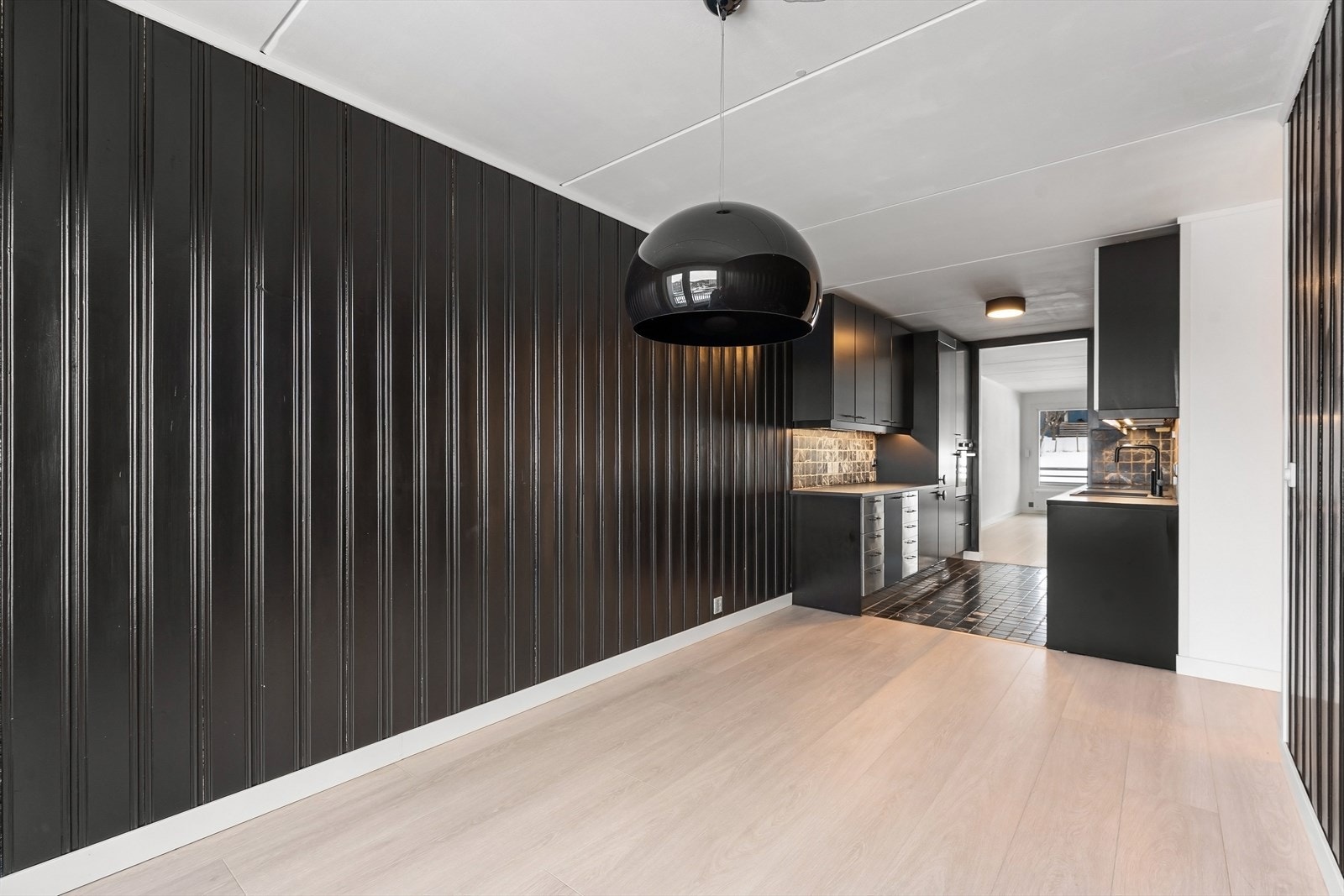 Spisestuen har tilsvarende utførelse som kjøkkenet med mørke vegger og lys himling samt gulv. Galleribilde