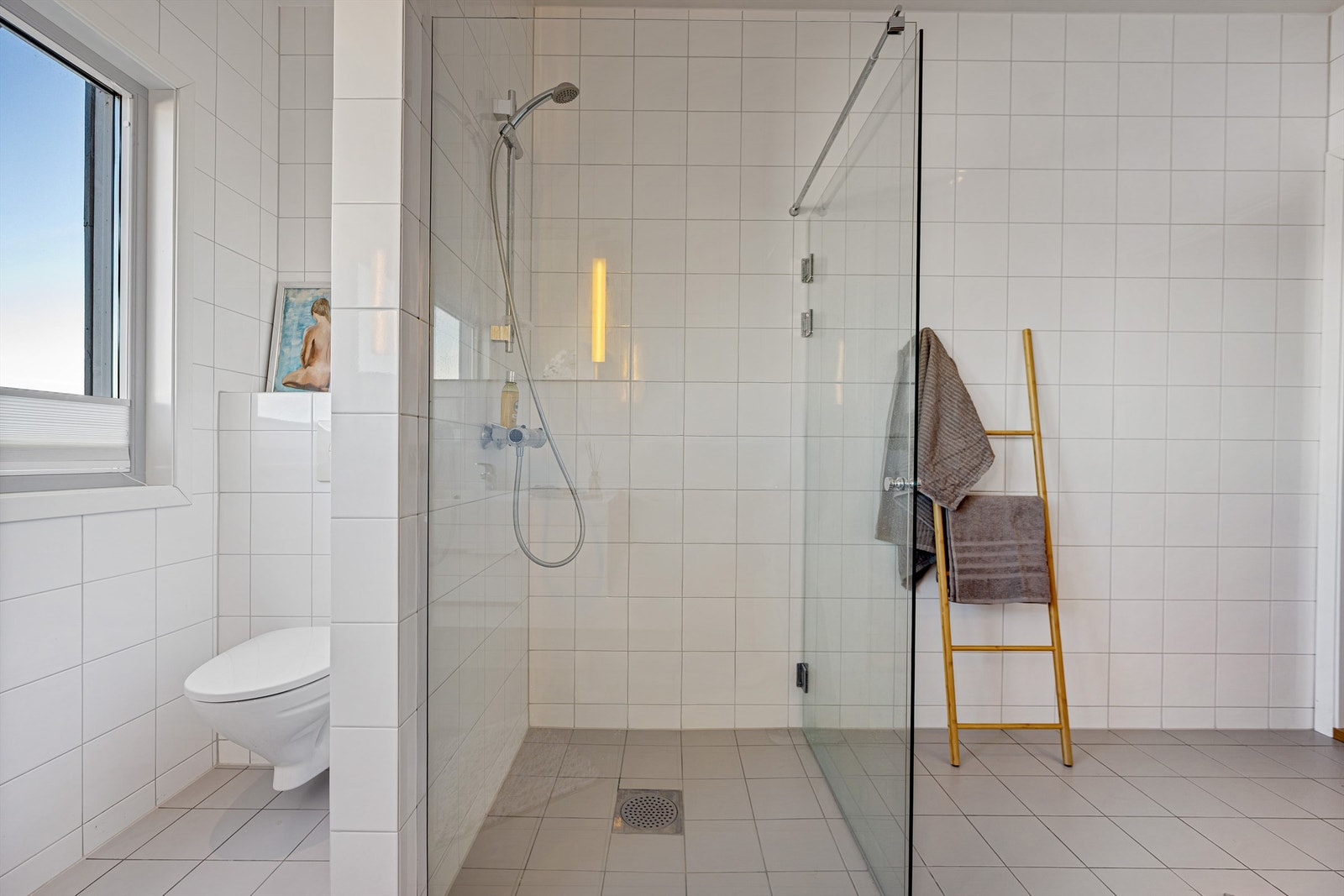 Rommet er utstyrt med dusjnisje med glassvegg og vegghengt toalett. Galleribilde