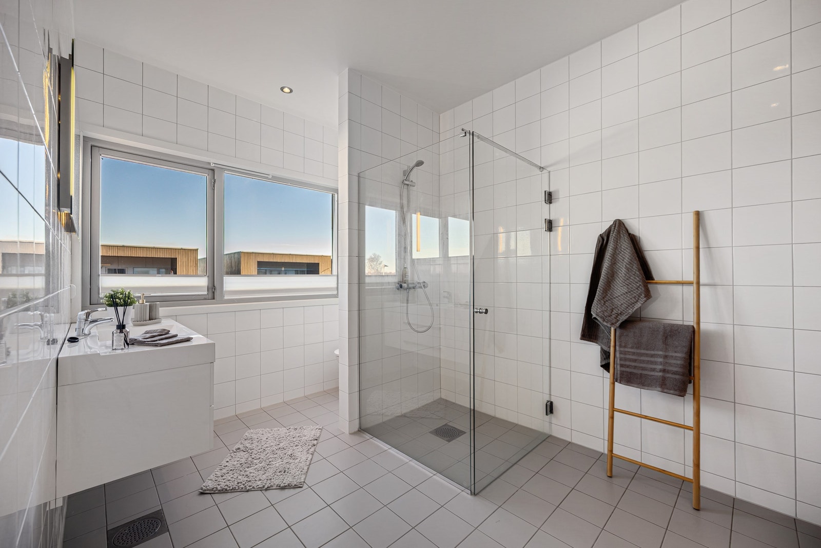 Badet er helfliset og har elektrisk gulvvarme for økt komfort. Baderomsinnredningen fra Aubo har en vegghengt servant med skuffer. Galleribilde