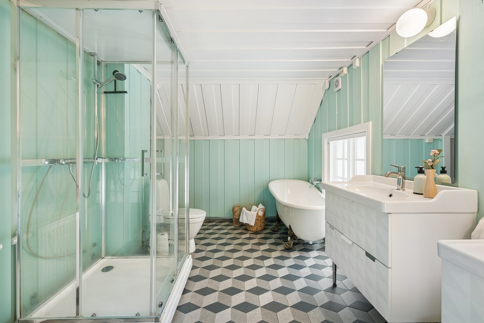 Baderom som er romslig og har både badkar og dusj Galleribilde