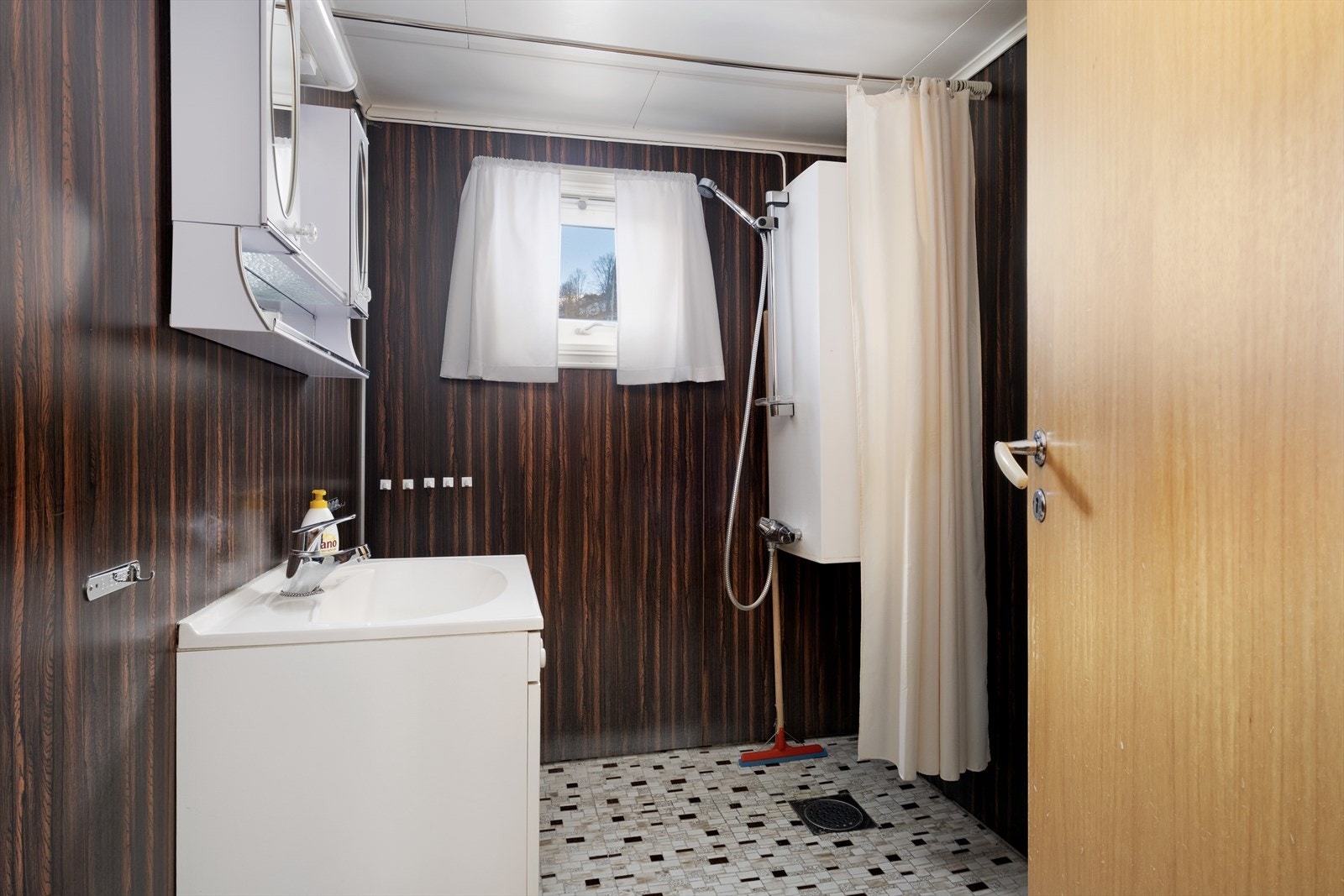 Enkelt bad som inneheld innreiing med vask, skap med speiglar og dusjforheng, Galleribilde