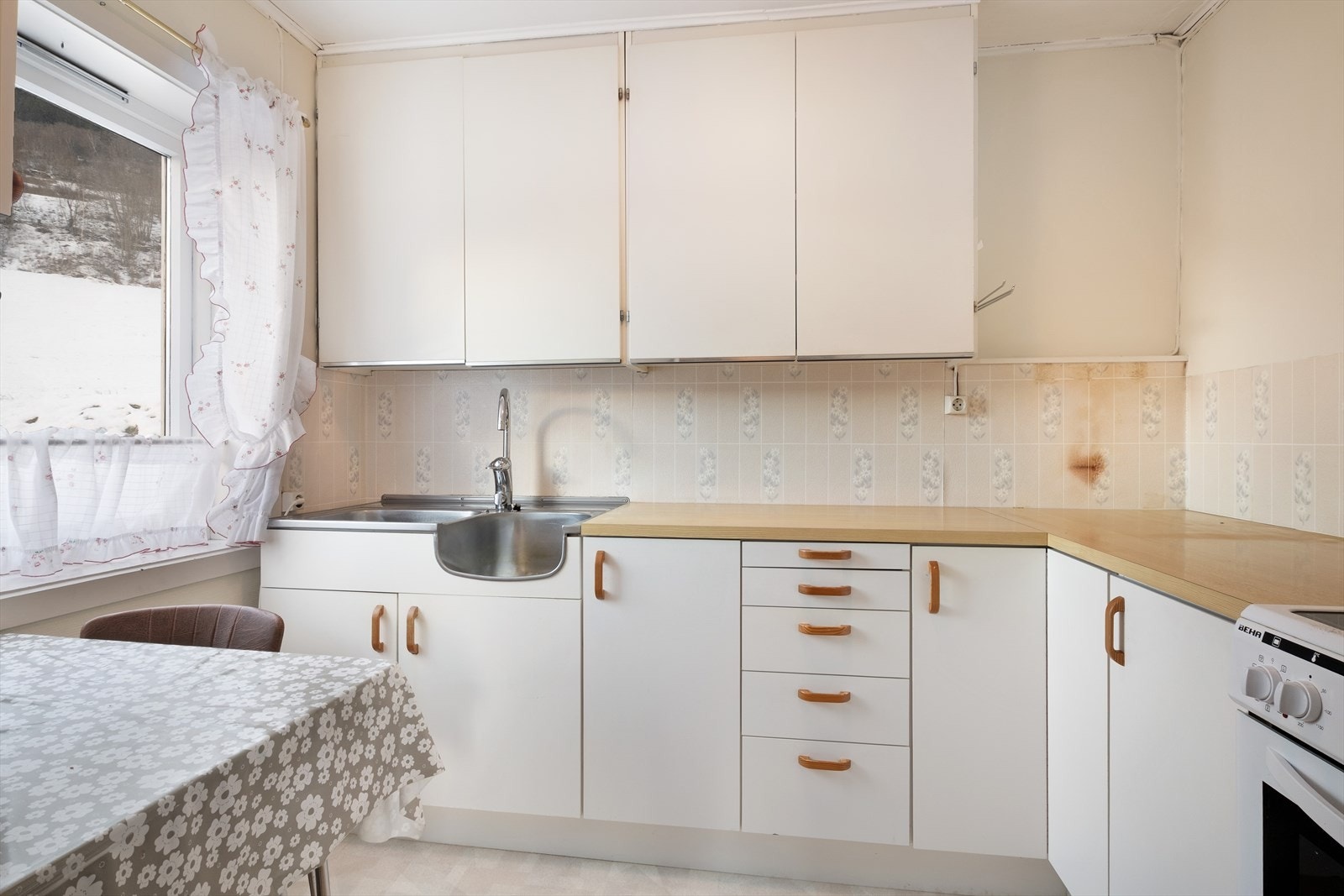 Enkelt kjøkken med innreiing med glatte frontar og benkeplate i laminat. Galleribilde