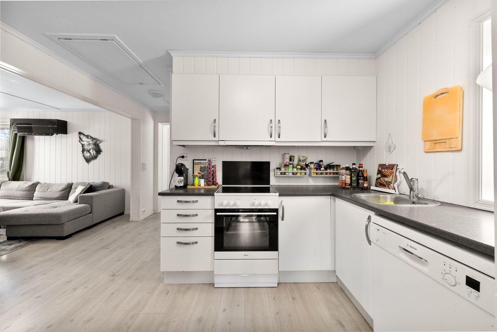 Kjøkkeninnredning fra Sigdal med hvite slette fronter og benkeplate av laminat. Galleribilde