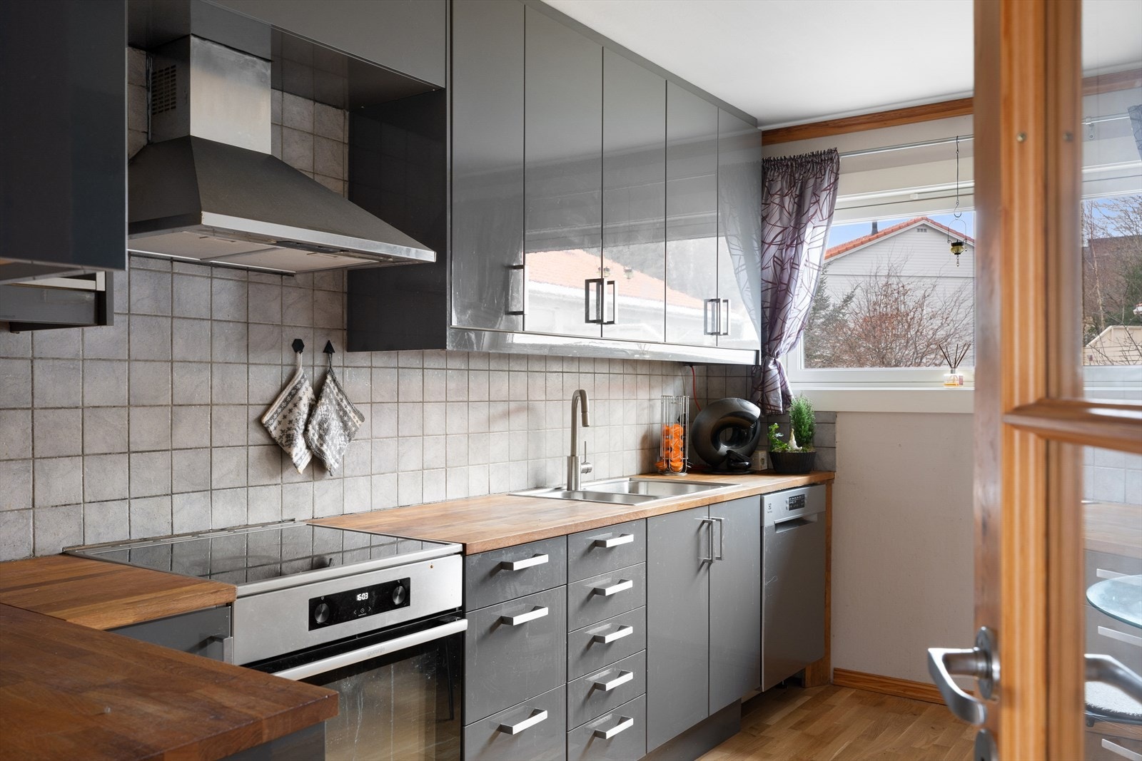 Kjøkkenet er adskilt fra stuen og er stilrent med slette, grå fronter. Galleribilde