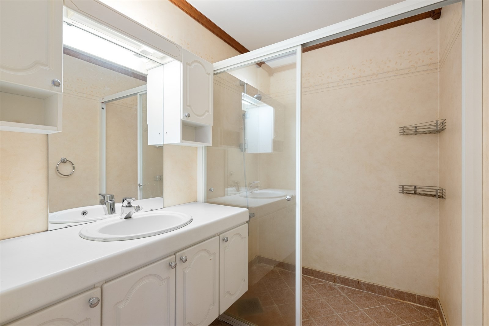 Badet har flislagt gulv med varmekabler og er innredet med servant og dusj med glassvegg. Galleribilde