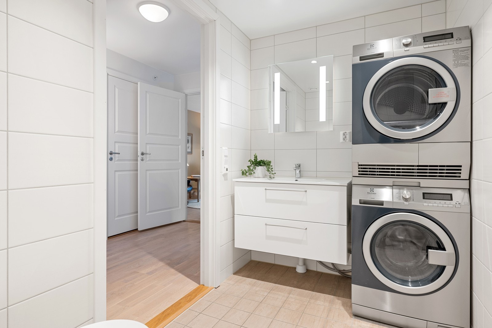 Romslig, flislagt bad fra 2022 med innredning med nedfelt servant og opplegg for vaskesøyle. Galleribilde