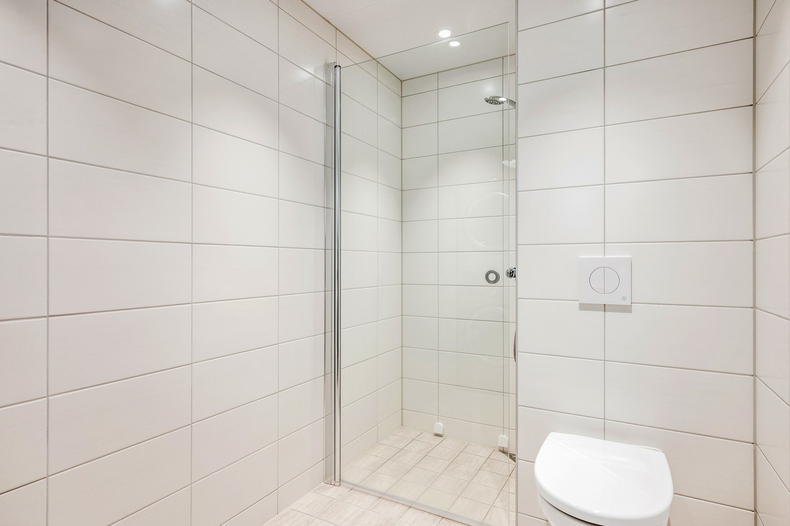 Badet er utstyrt med et praktisk dusjhjørne med innfellbare glassdører og vegghengt toalett. Galleribilde