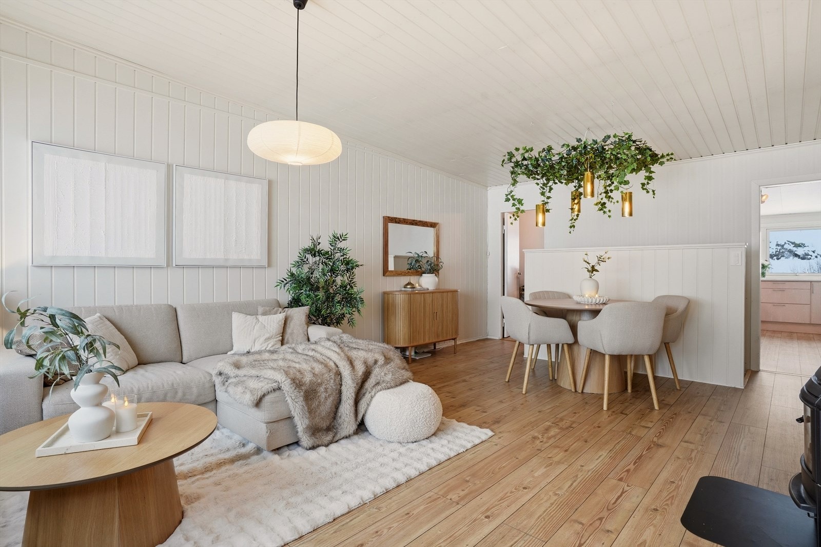 Stuen er lys og innbydende med 1-stavs laminat på gulv og hvitmalt panel på vegger. Galleribilde