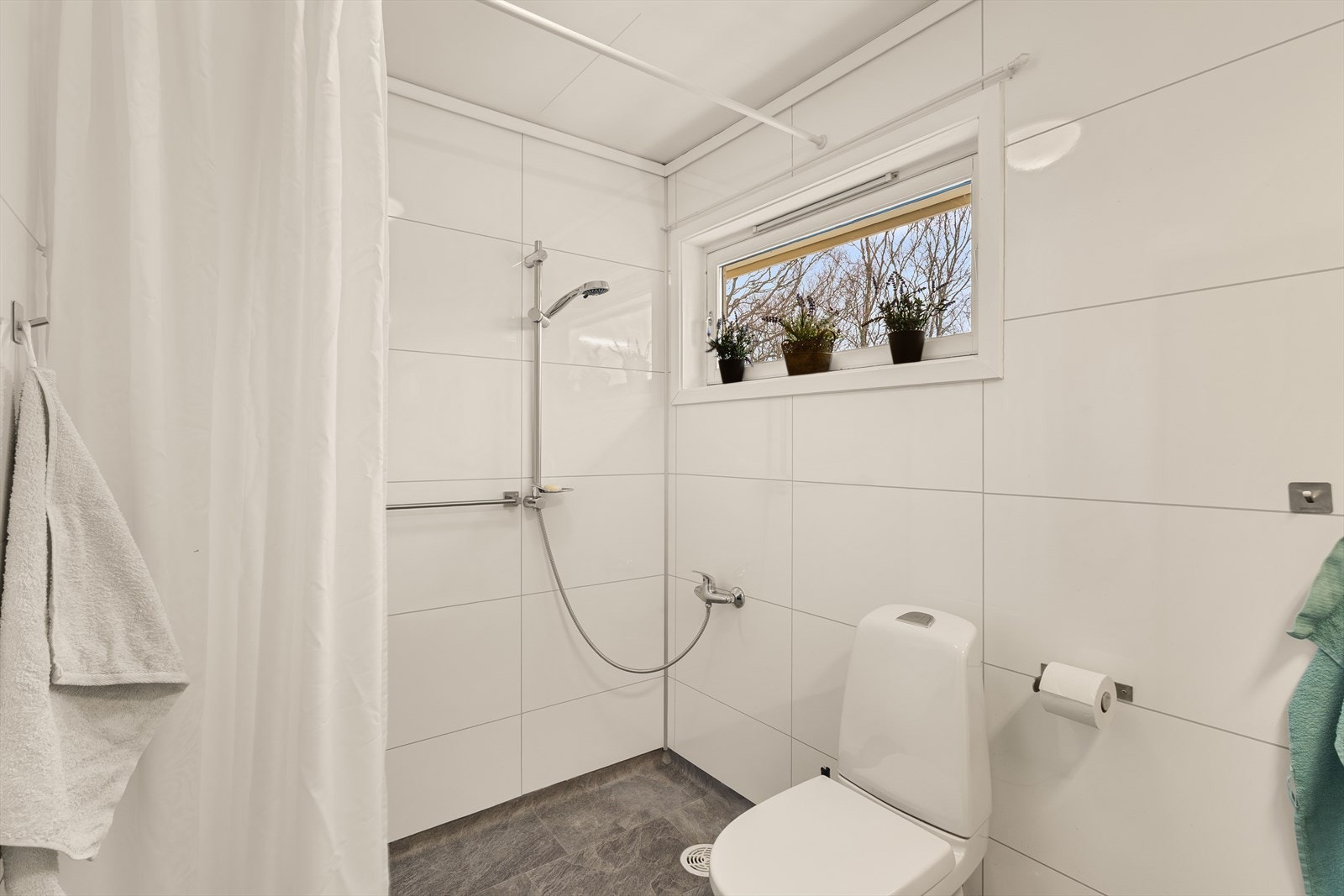 Bad har innredning med nedfelt servant, toalett og dusjvegger/ hjørne. Galleribilde