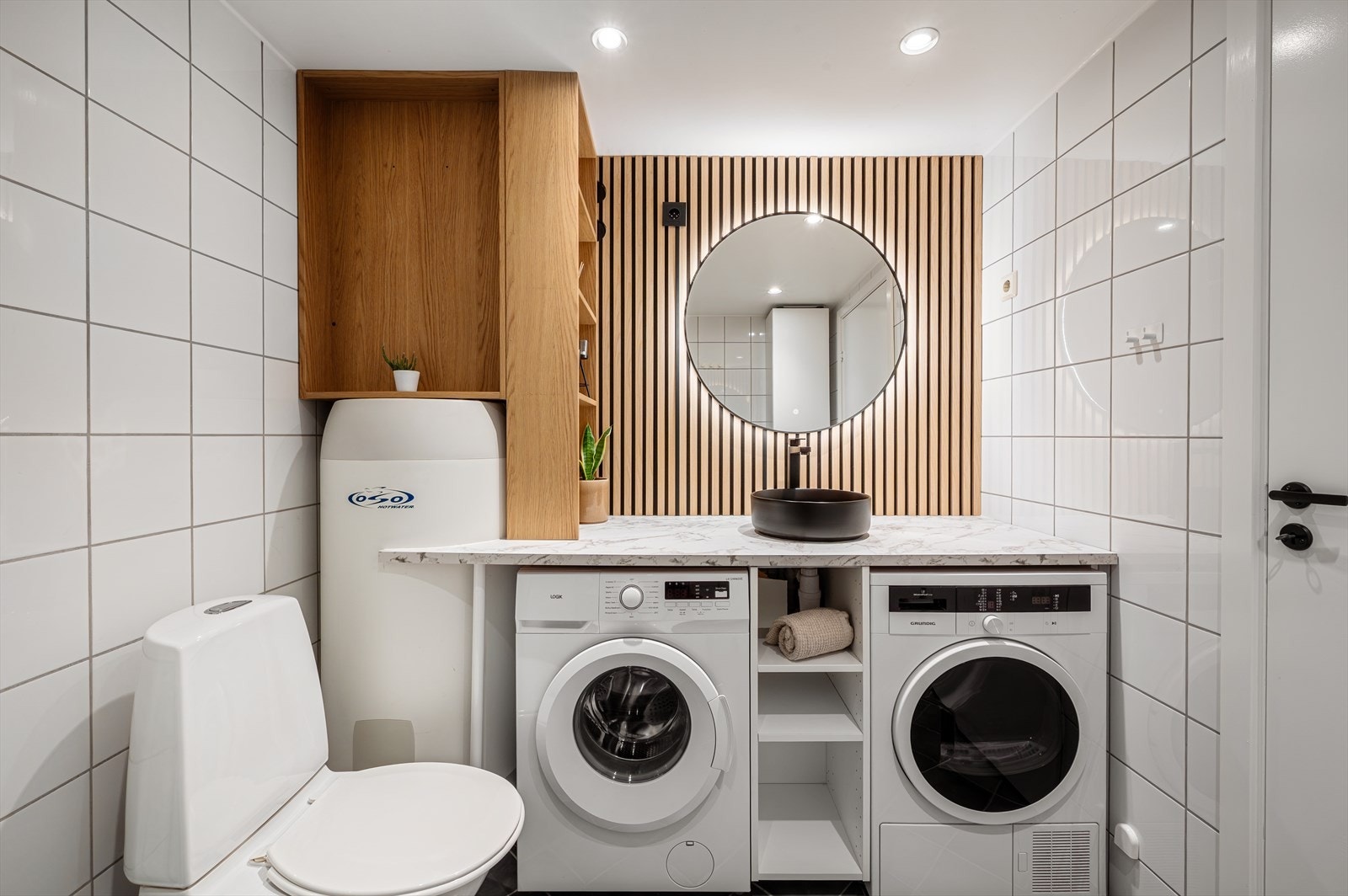 - Badet er innredet med toalett, benkeskap med servant, opplegg for vaskemaskin og dusjhjørne - Galleribilde