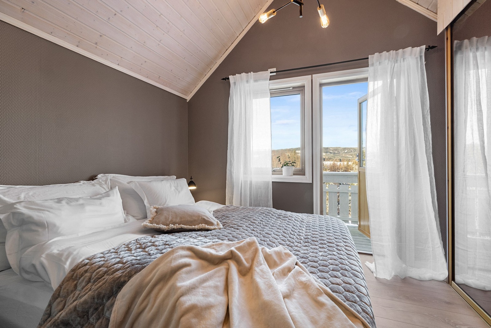 Lyst og innbydende soverom med dør ut til egen balkong Galleribilde