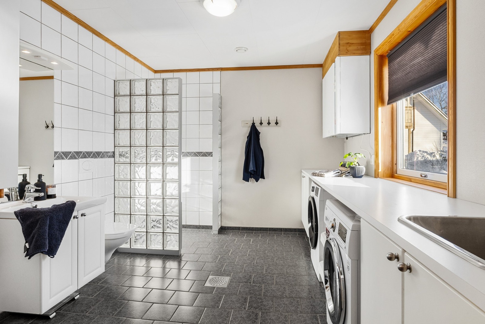 Badet er romslig og inkluderer praktisk vaskeromsfunksjon for enkel hverdag Galleribilde