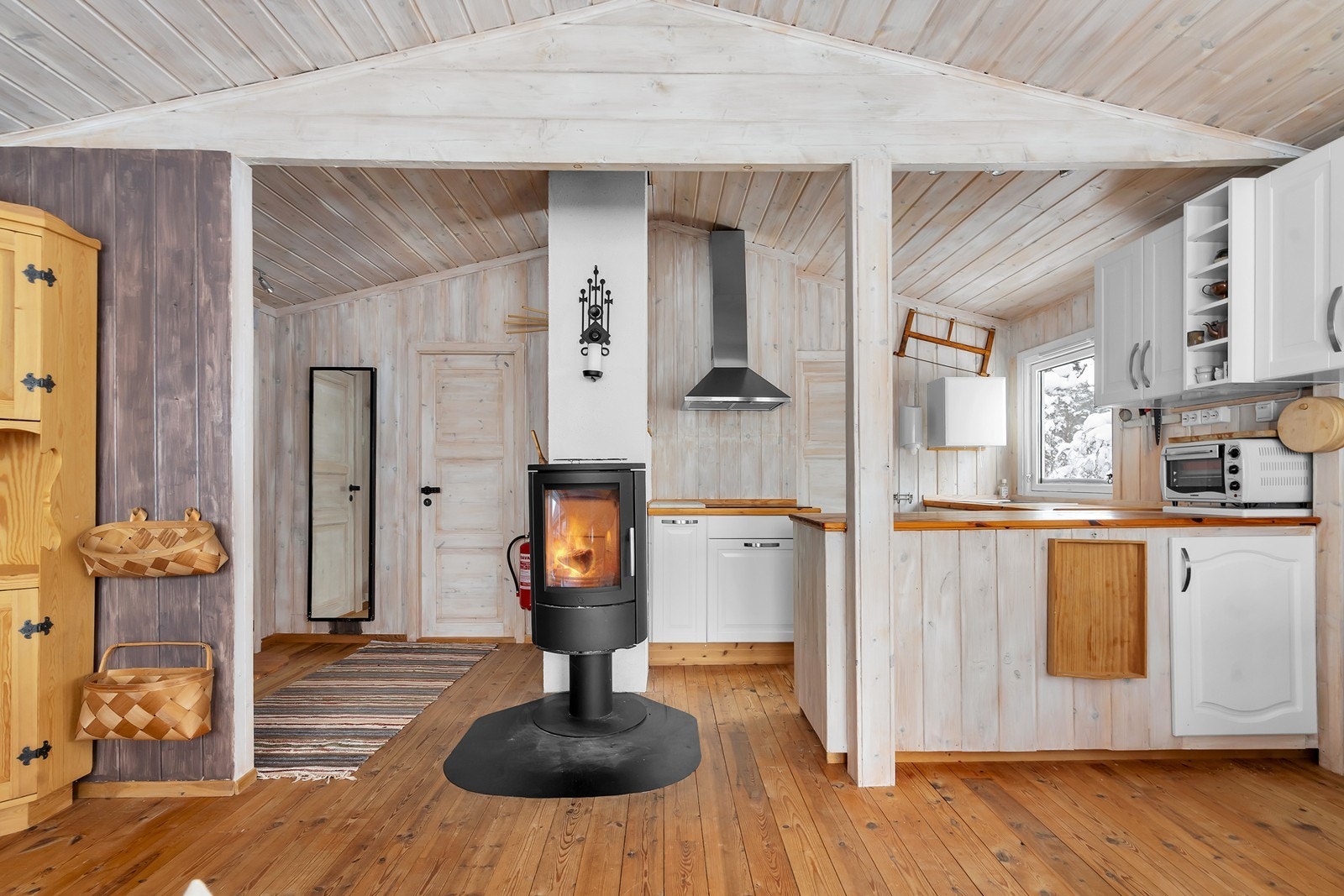 Vedfyrt ovn i stue som bidrar til både hygge og varme på kaldere dager Galleribilde