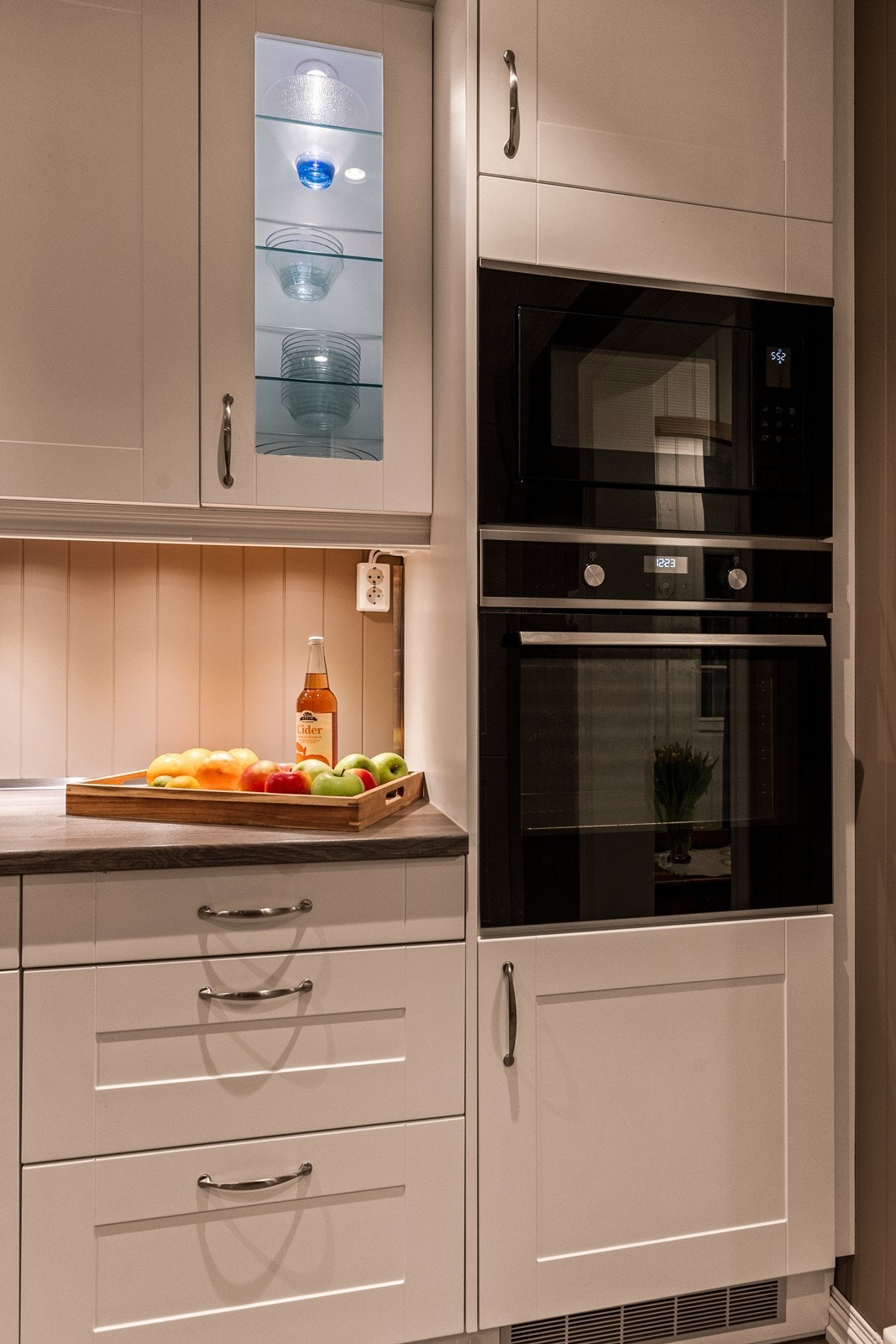 Detaljer som vitrineskap med belysning gir kjøkkenet et elegant preg. Galleribilde