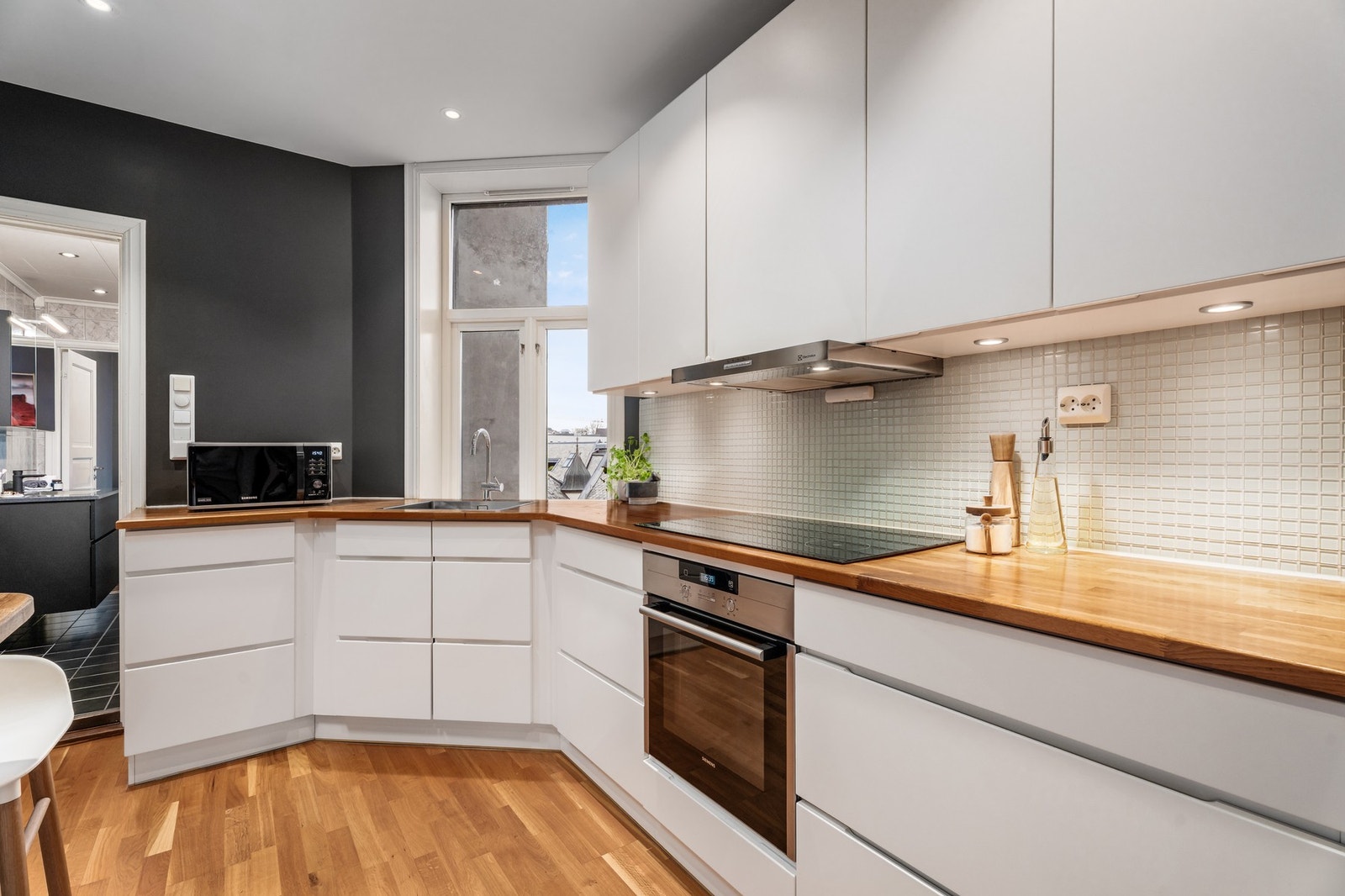 Stilrent kjøkken fra Kvik med rikelig skapplass og romslige arbeidsflater. Glatte fronter kombinert med benkeplate i heltre. Galleribilde