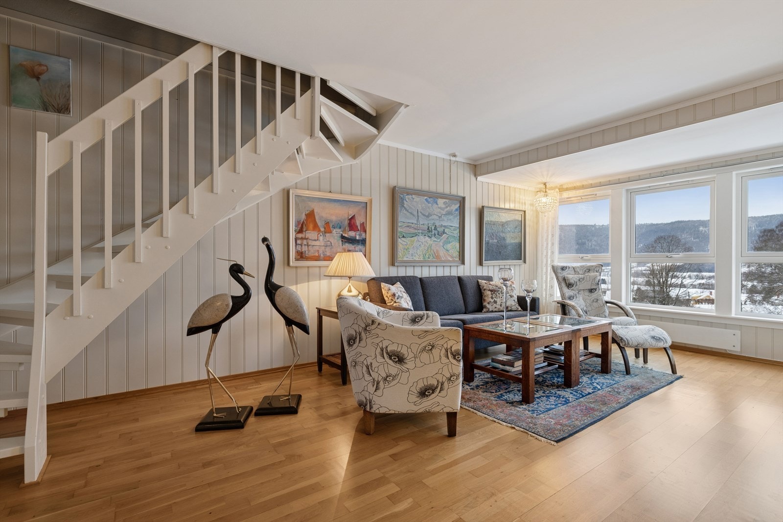 Lys stue med store vindusflater som slipper inn rikelig med dagslys og gir en åpen og luftig romfølelse. Galleribilde