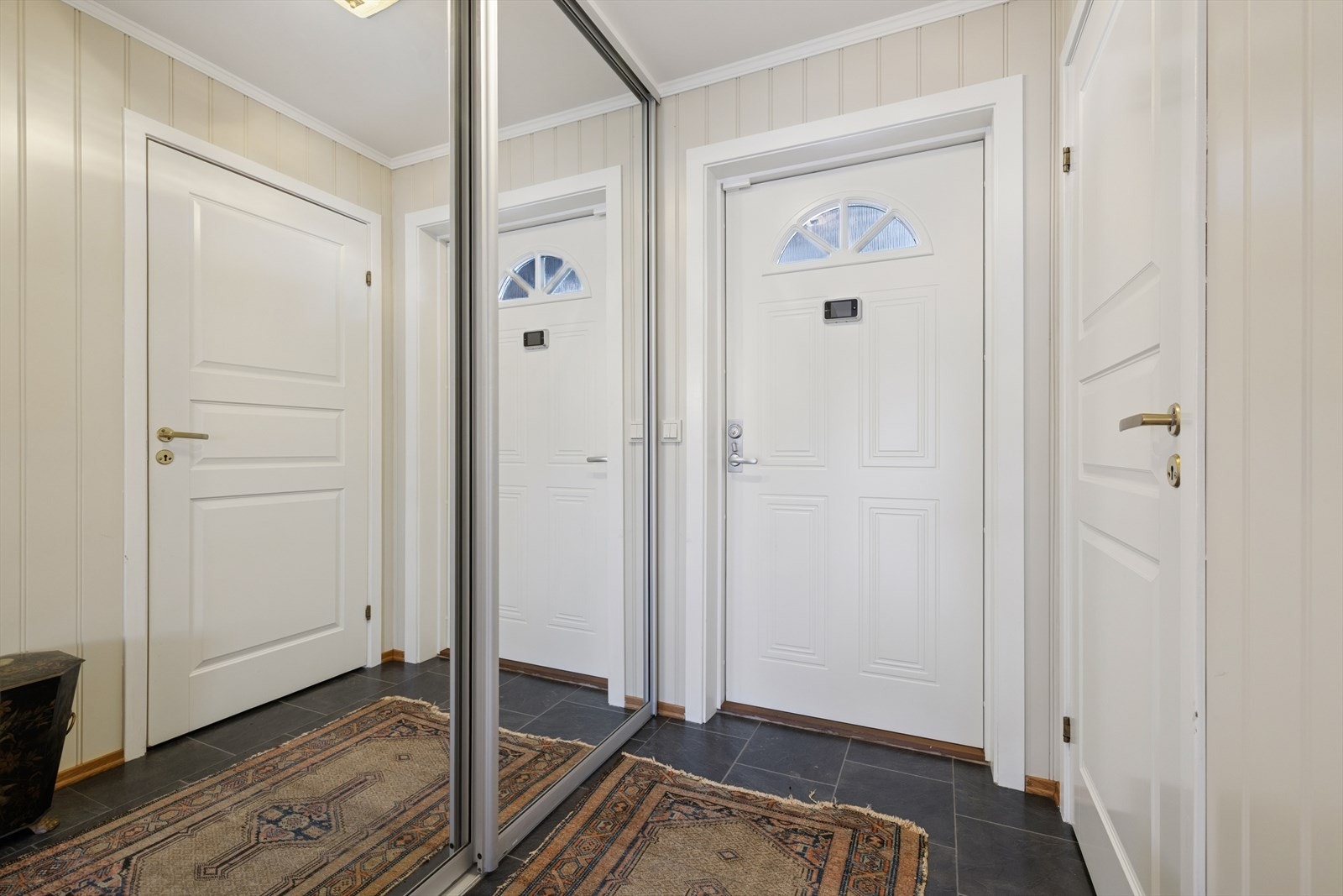 Lys og innbydende entré med praktisk skyvedørsgarderobe med speilfronter, som gir gode oppbevaringsmuligheter. Galleribilde