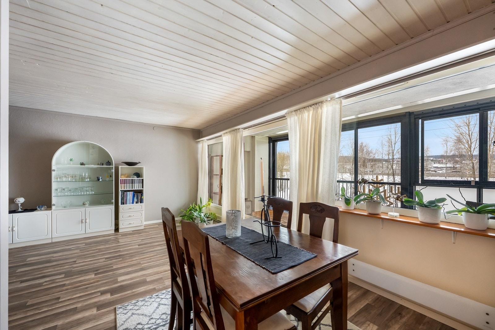 Store vinduer gir godt med dagslys til spiseområdet i stuen. Galleribilde